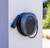 Pod Point home charger mounted on a white exterior wall, with cable neatly wrapped.