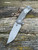 Hinderer Project X Magnacut with horse head engraved titanium scale.
