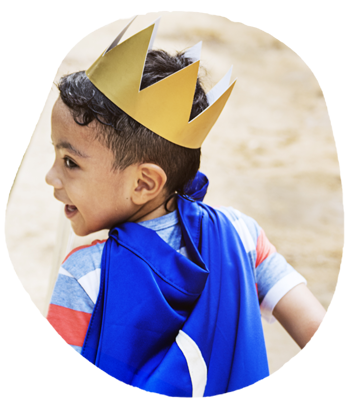 Little boy wearing a crown and cape