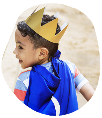 Little boy wearing a crown and cape