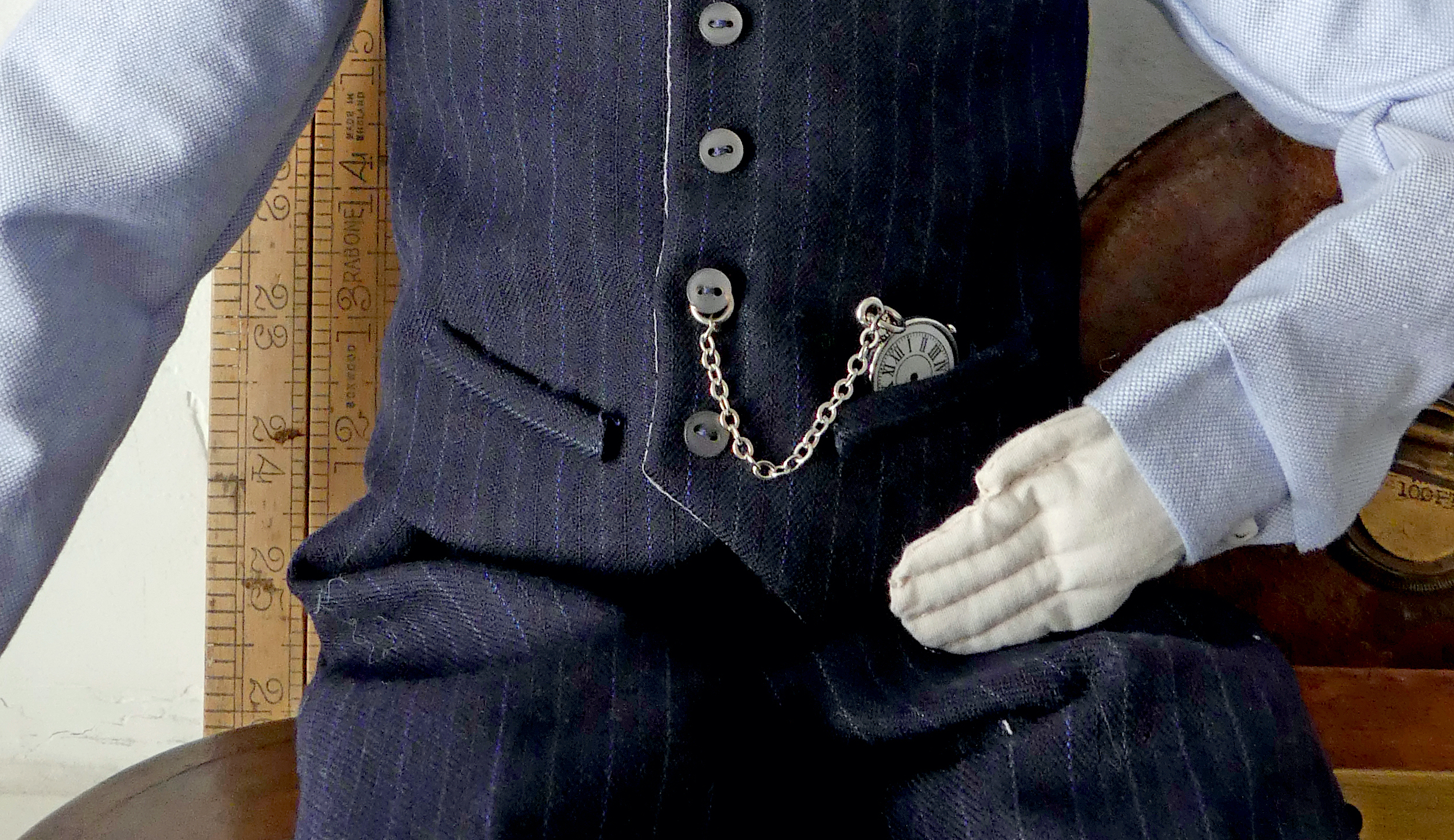 How to put a belt bar chain pocket watch through a waistcoat like this?  I've tried a few ways but I'd like to know a secure way so that the chain  looks