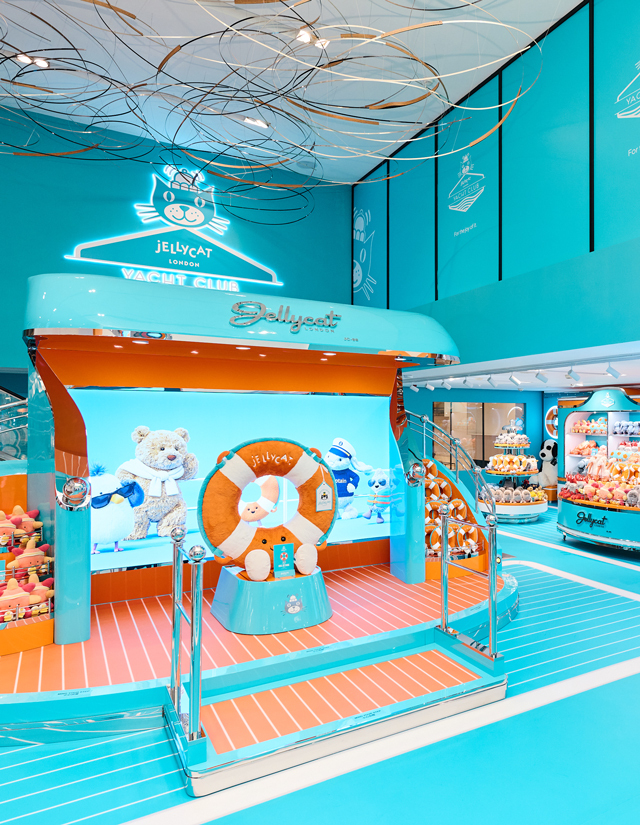 Vue d’ensemble de l’installation Jellycat Yacht Club, avec des présentoirs nautiques turquoise et orange.