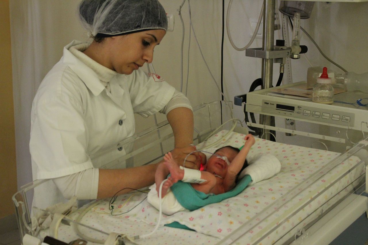 Nurse caring for baby in Holy Family Hospital