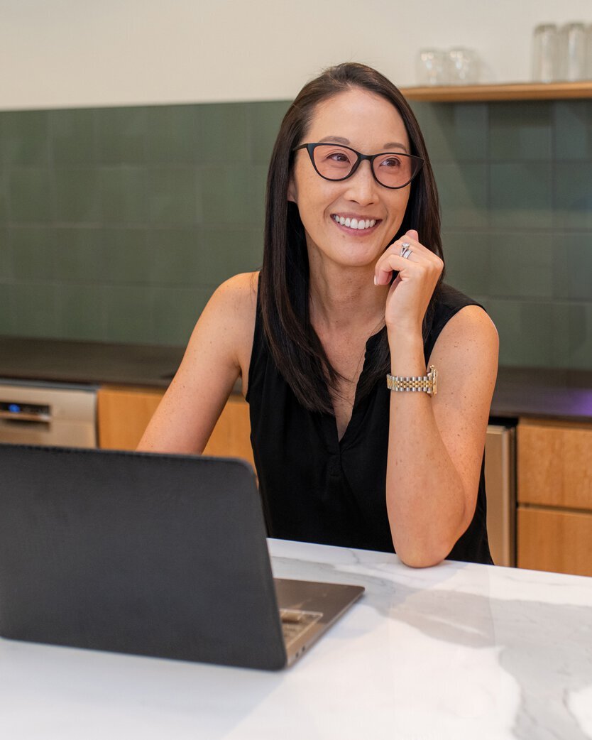 Woman wearing TheraSpecs therapeutic glasses with Flex lenses for computer use