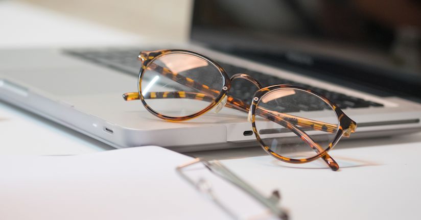 Clear blue light glasses sitting on top of computer