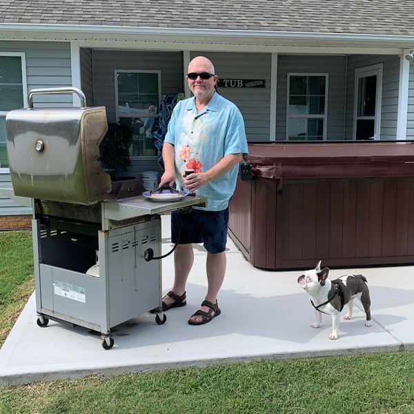 David wearing outdoor custom TheraSpecs while grilling with his dog