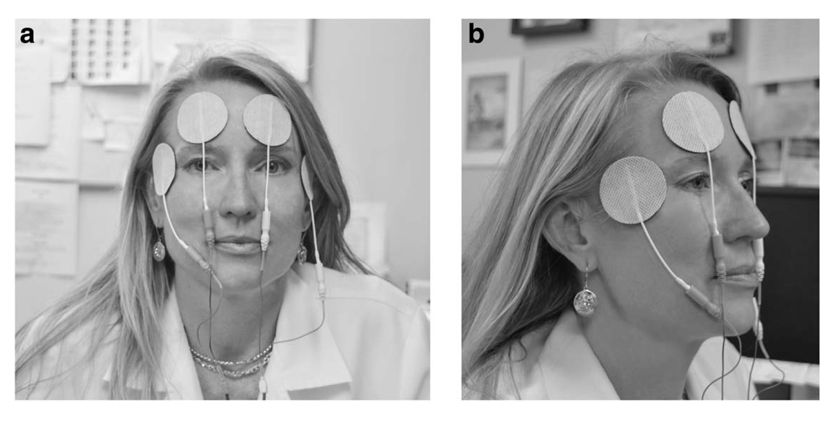 Woman trying TENS unit for ocular pain