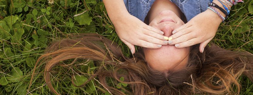 Young girl hiding eyes from bright light