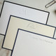 Your Logo Embossed on 4.5 x 6.25 Flat Cards at StationeryXpress.com - White Card in back with Black Border, 2 in front with navy border - Close Up