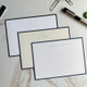 Your Logo Embossed on 4.5 x 6.25 Flat Cards at StationeryXpress.com - White Card in back with Black Border, 2 in front with navy border
