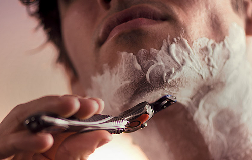 Razor shaving along the chin and neck with shaving cream for a close, against‑the‑grain shave