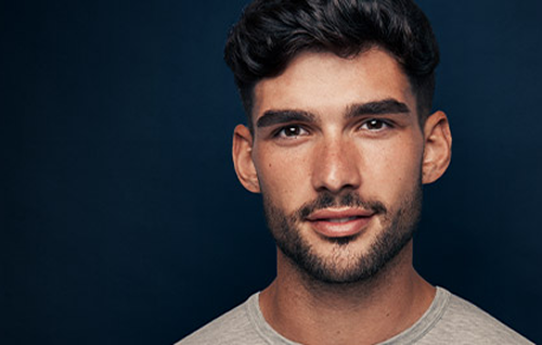 Evenly trimmed short stubble beard showing a maintained three‑day scruff look