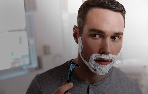 Razor shaving facial hair with shaving cream, demonstrating the use of shave gels and foams