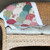 Finished clamshell quilt in pinks and greens over the back of a couch
