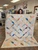 Pastel pumpkin seed quilt finished showing in a quilt shop