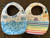 Two rainbow colored washcloth bibs