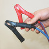 Hands holding 100 amp clamps affixed to Arctic Superflex Blue cable in a jumper cable configuration
