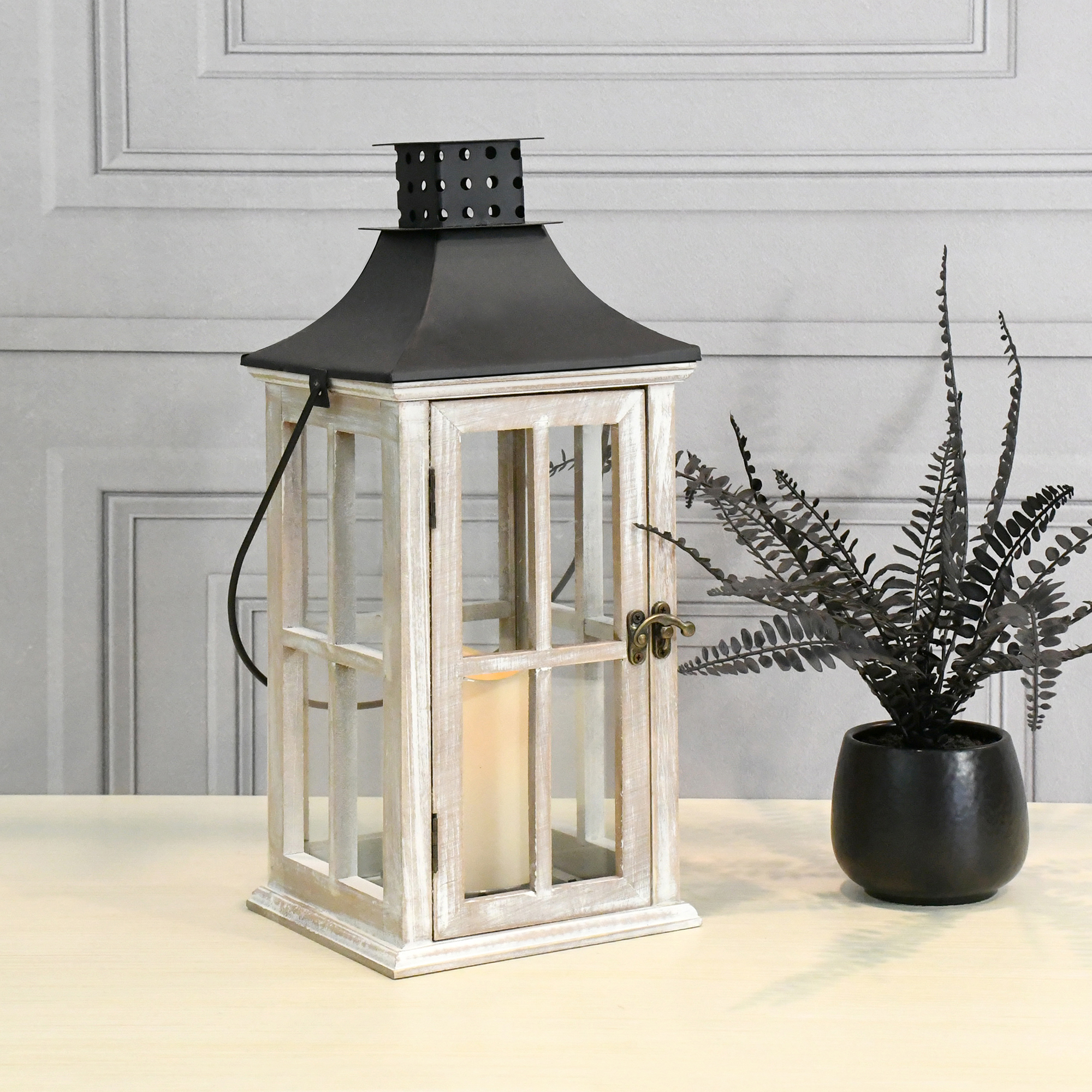 White wood and metal lantern with votive candle light up the table.