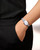 Longines Flagship watch, silver stainless steel bracelet and round white dial with Roman numeral hour markers, on woman's wrist with black outfit.