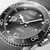 Longines HydroConquest Watch, close-up view of the stainless steel case, black bezel, and gray dial with luminous hands and markers, featuring date display and water resistance up to 300 meters.