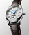 Longines The Longines Master Collection [L2.409.4.78.3] watch, close-up view of a luxury wristwatch with a white textured dial, blue hands, moon phase display, and brown leather strap.