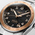 Longines L3.803.5.53.6 watch, detailed close-up of the black dial with gold-tone bezel, silver bracelet, and chronograph features.