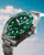 Longines HydroConquest watch, green dial and stainless steel bracelet with a blue sky background.