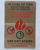 IN CASE OF FIRE ELEVATORS ARE OUT OF SERVICE USE EXIT STAIRS COMPLIANCE SIGN