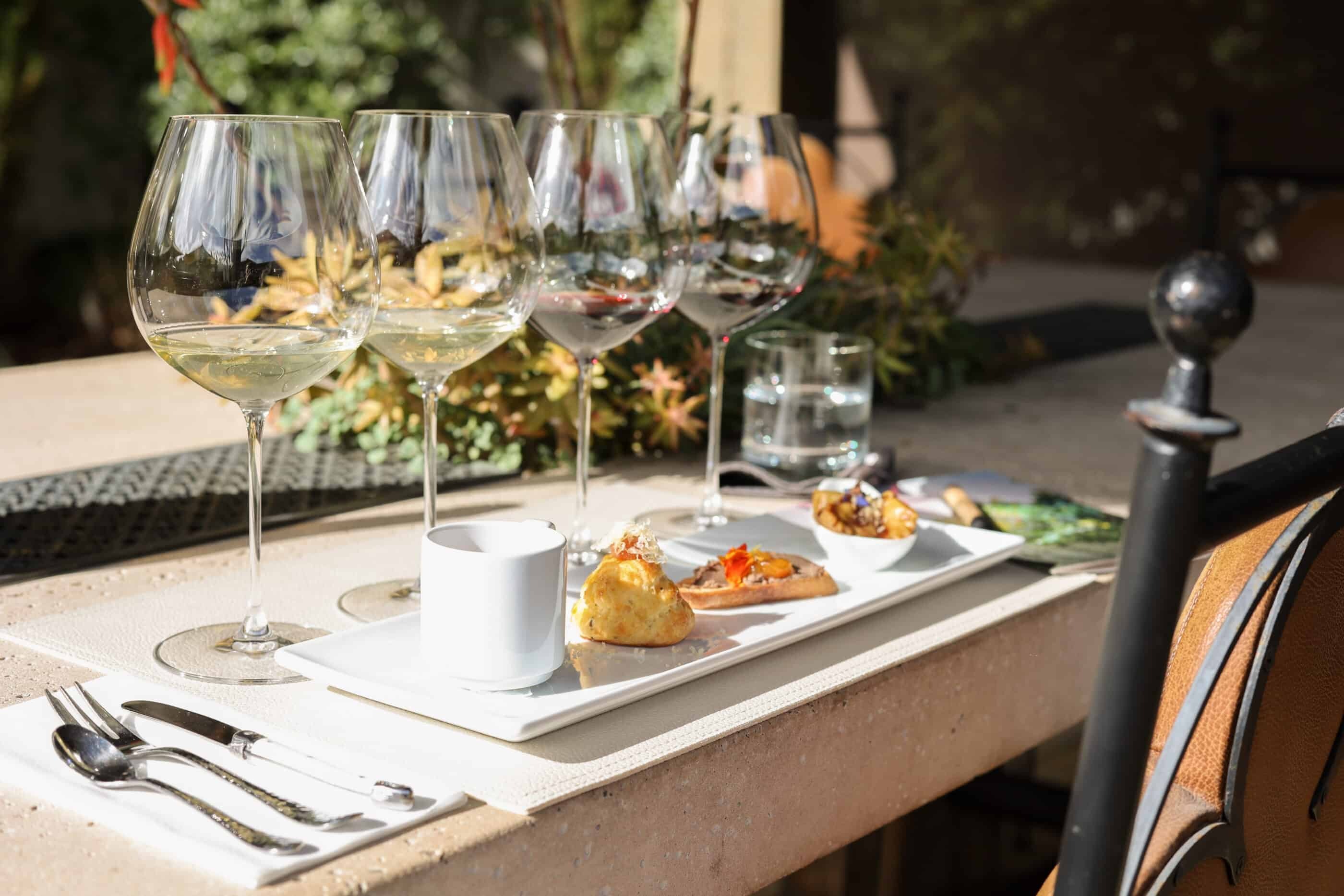 Table served with glasses of different wines and food