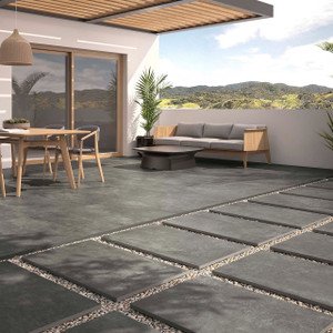 Outdoor patio setting featuring Slater Dark Grey 60x90cm tiles with a modern garden lounge and timber dining furniture. Outdoor patio setting featuring Slater Dark Grey 60x90cm tiles with a modern garden lounge and timber dining furniture.
