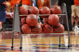 Basketballs on a rack in the middle of a basketball court