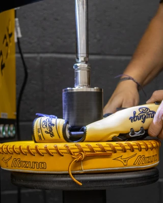 The DR3K glove break-in machine pressing a tan and navy baseball glove at Burghardt Sporting Goods in New Berlin, Wisconsin