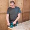 Makita BO5041K 3 Amp 5in Random Orbit Sander Kit showing in use sanding down a wood work table Makita BO5041K 3 Amp 5in Random Orbit Sander Kit showing in use sanding down a wood work table