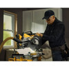 DeWalt DCS785B 20V MAX XR Cordless 12in Double Bevel Sliding Mitre Saw (Tool Only) showing in use cutting moulding with saw mounted on stand with vacuum attached (Battery, stand, and vacuum sold separately)