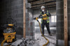 DeWalt DCH911Z2 60V MAX Cordless Brushless 27 LBS SDS MAX Inline Chipping Hammer Kit showing in use chipping down a cinder block concrete wall creating a hole for a door