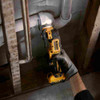 DeWalt DCS353B XTREME 12V MAX Cordless Brushless Oscillating Multi Tool (Tool Only) showing in use cutting plumbing pipe between wood studs