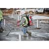 Milwaukee MXF371-2XC MX FUEL Cordless Brushless Backpack Concrete Vibrator Kit showing in use vibrating a slab of concrete