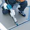 Makita DCG180ZB 18V Cordless 600ml Caulking Gun (Tool Only) showing in use sealing between industrial tiles