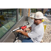 Milwaukee 2441-20 M12 Cordless 10oz. Caulk and Adhesive Gun (Tool Only) showing in use sealing windows on side of the wall
