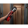 Milwaukee 2473-22 M12 FORCE LOGIC Cordless Press Tool Kit with Jaws Kit showing in use crimping copper pipe between wall studs