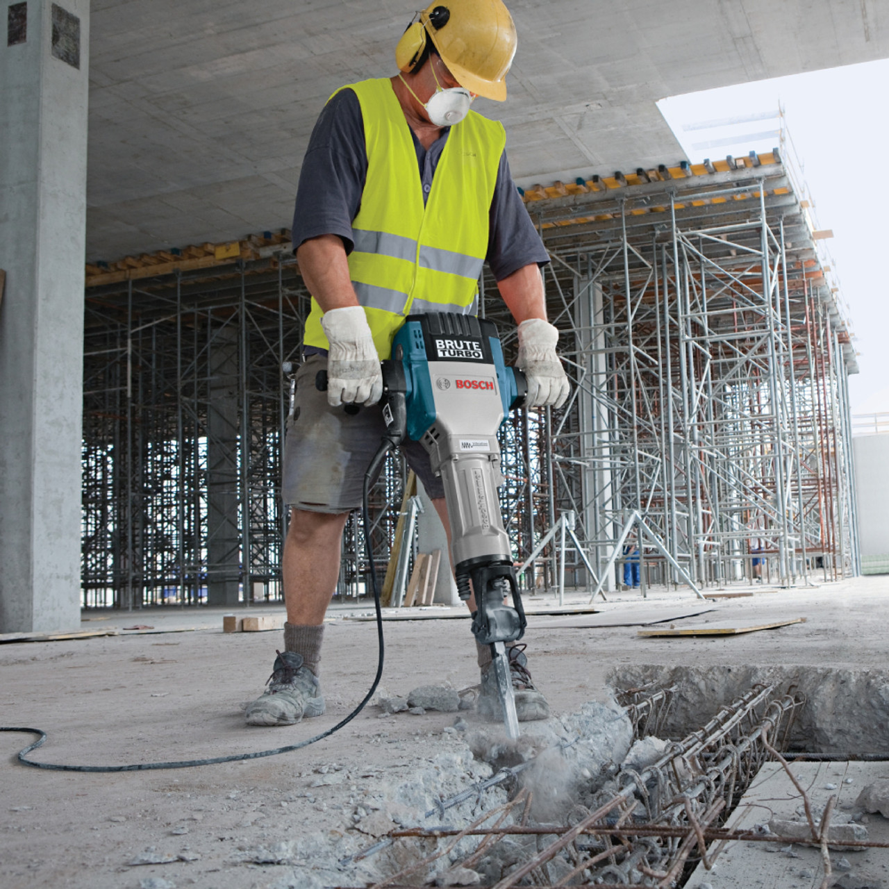 Bosch BH2770VCD Brute Turbo 15 Amp 1-1/8 inch Hex Breaker Hammer with Deluxe Cart showing in use demolishing concrete slab on a job site