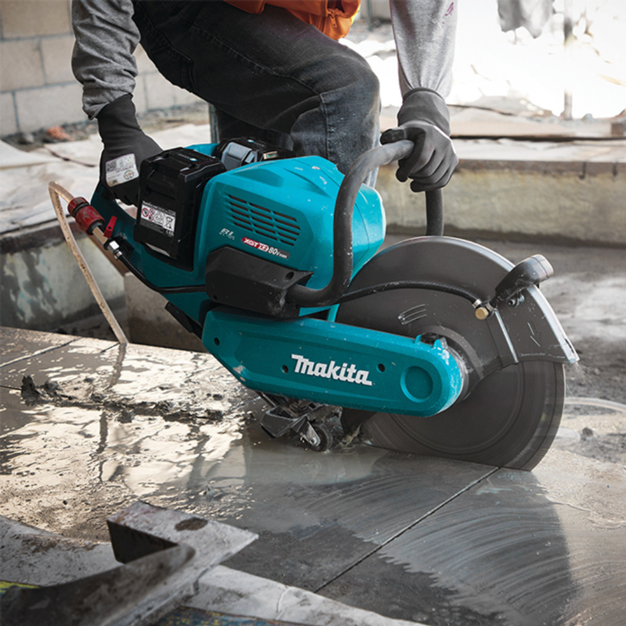 Makita CE001GL401 80V Max (40Vx2) XGT Cordless Brushless 14 inch Power Cutter Kit showing in use cutting into a slab of concrete Makita CE001GL401 80V Max (40Vx2) XGT Cordless Brushless 14 inch Power Cutter Kit showing in use cutting into a slab of concrete