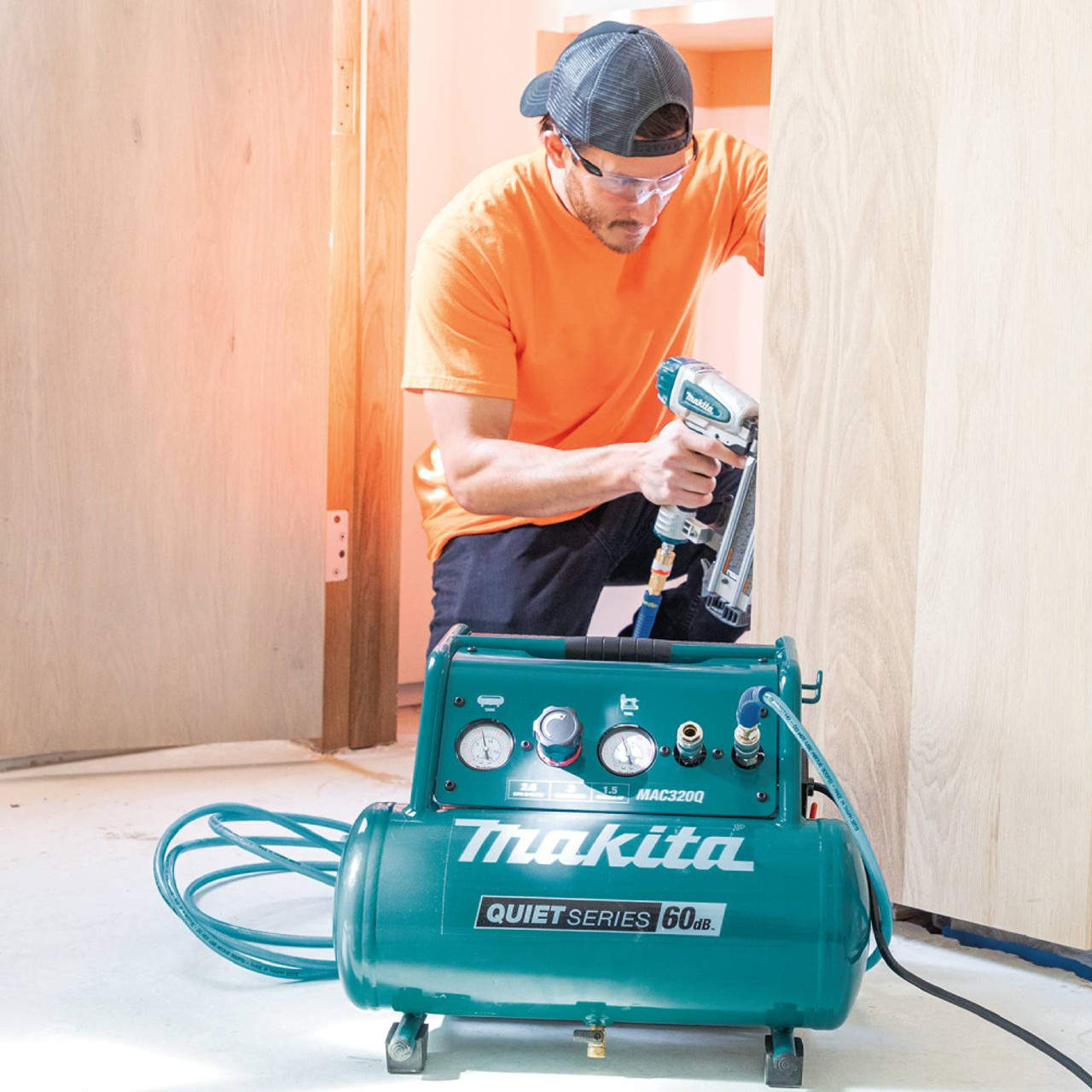 Makita MAC320Q 8.5 Amp 1.5 HP 3 Gallon Quiet Air Compressor showing compressor in use supplying air to a brad nailer Makita MAC320Q 8.5 Amp 1.5 HP 3 Gallon Quiet Air Compressor showing compressor in use supplying air to a brad nailer