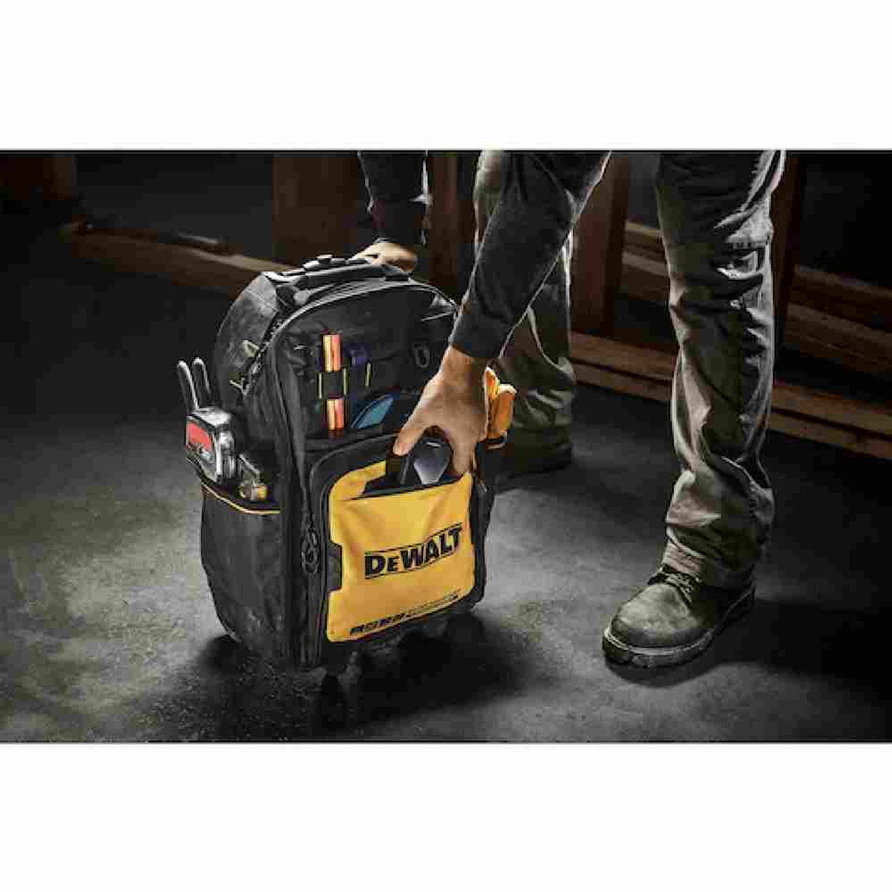 DeWalt DWST560101 Professional Backpack on Wheels showing on jobsite with contractor retrieving tools from the front pocket (Tools sold separately) DeWalt DWST560101 Professional Backpack on Wheels showing on jobsite with contractor retrieving tools from the front pocket (Tools sold separately)