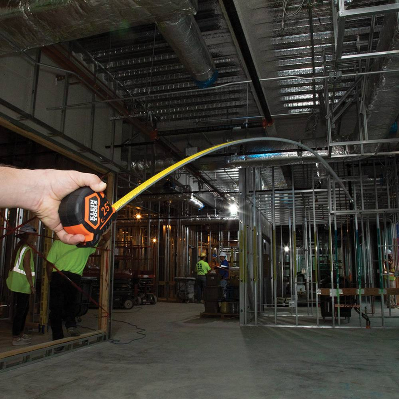 Klein Tools 9125 25-feet Single-Hook Tape Measure showing in use measuring distance of a room