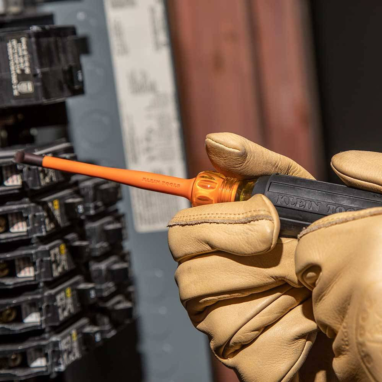 Klein Tools 94130 5pc 1000V Insulated Tool Kit showing in use fastening breakers to panel