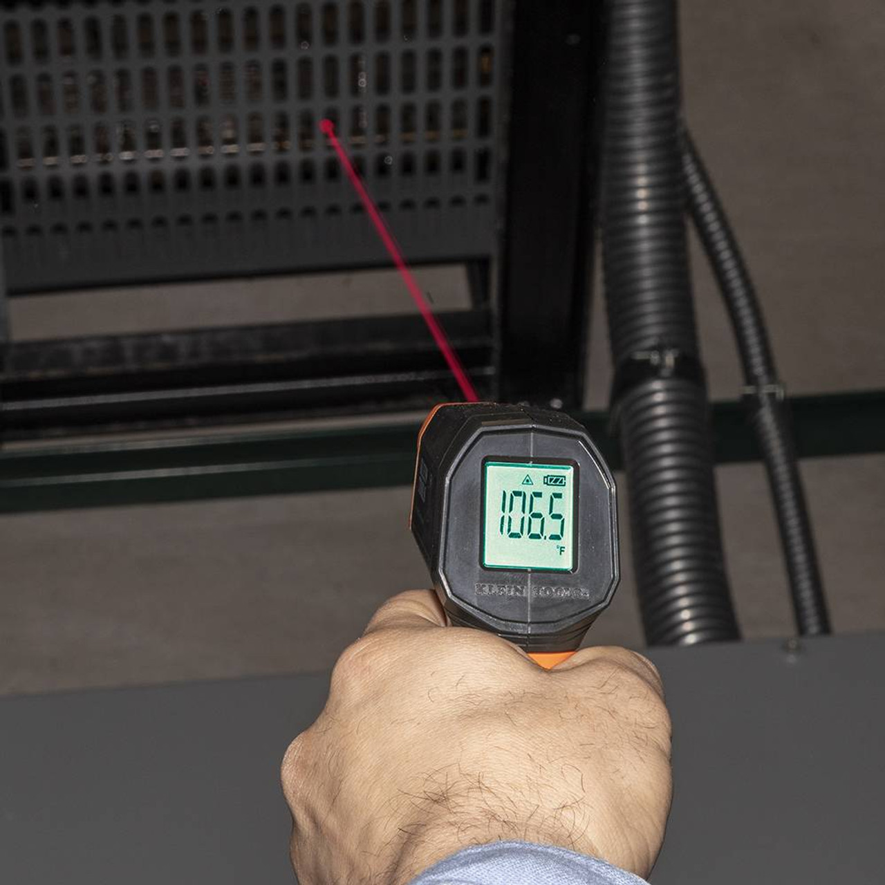 Klein Tools IR1 10:1 Infrared Digital Thermometer with Targeting Laser showing in use reading heat at vent of furnace Klein Tools IR1 10:1 Infrared Digital Thermometer with Targeting Laser showing in use reading heat at vent of furnace