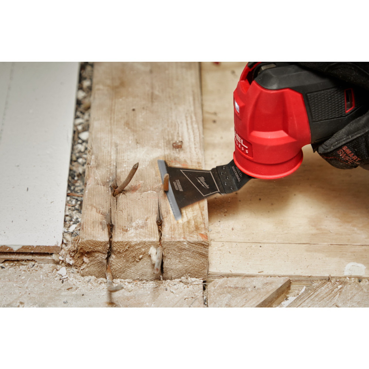 Milwaukee 49-25-1241 OPEN-LOK 2-1/2-inch Universal Fit Titanium Enhanced Bi-Metal Multi-Material Cutting Multi-Tool Oscillating Blade showing in use cutting nail sticking out of a 2 inchX4 inch wood stud Milwaukee 49-25-1241 OPEN-LOK 2-1/2-inch Universal Fit Titanium Enhanced Bi-Metal Multi-Material Cutting Multi-Tool Oscillating Blade showing in use cutting nail sticking out of a 2 inchX4 inch wood stud
