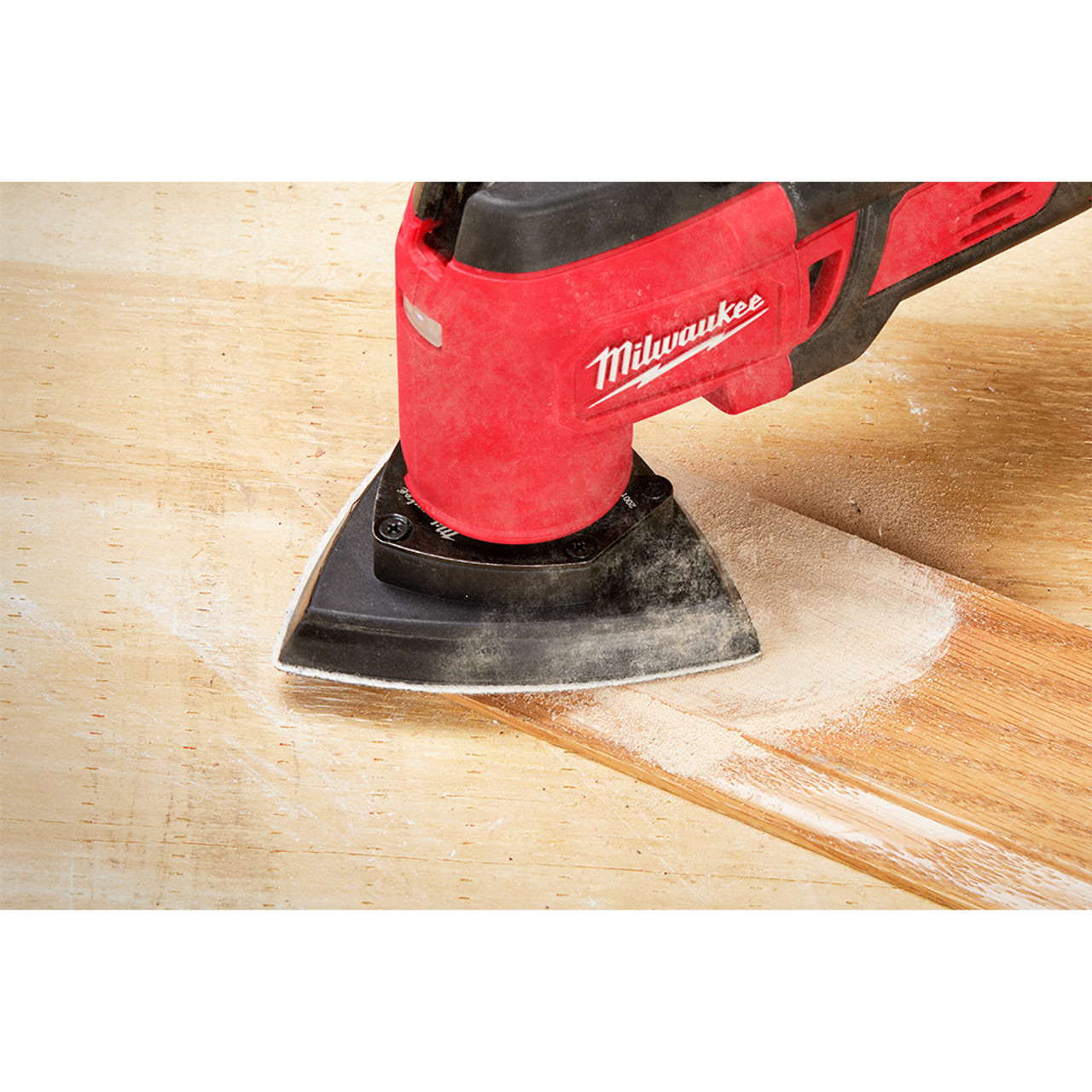 Milwaukee 49-25-2009 OPEN-LOK 10pc 3-1/2-inch Triangle Universal Fit Multi-Tool Oscillating Sanding Pad & Paper Set showing in use sanding finish off of baseboards Milwaukee 49-25-2009 OPEN-LOK 10pc 3-1/2-inch Triangle Universal Fit Multi-Tool Oscillating Sanding Pad & Paper Set showing in use sanding finish off of baseboards