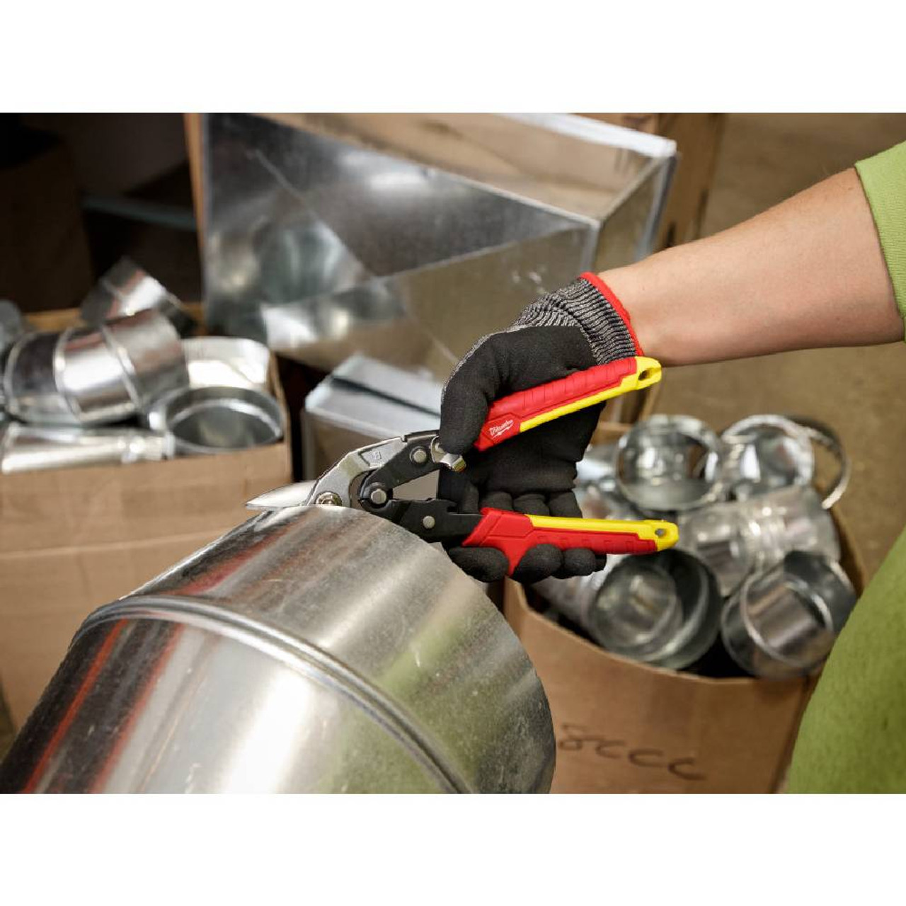 Milwaukee 48-22-4569 18GA Bulldog Aviation Snips showing in use cutting through metal ducting Milwaukee 48-22-4569 18GA Bulldog Aviation Snips showing in use cutting through metal ducting